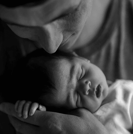Father kissing his newborn