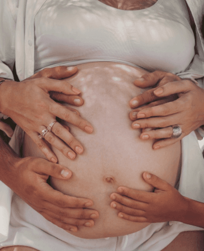 Hands tenderly resting on a pregnant belly