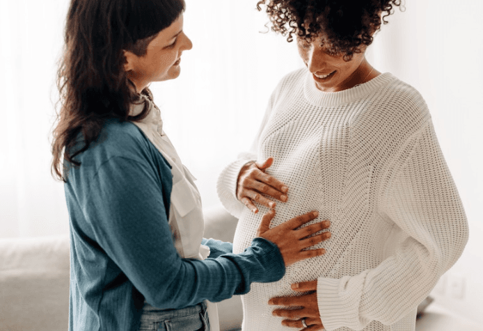 Surrogate being comforted by a friend